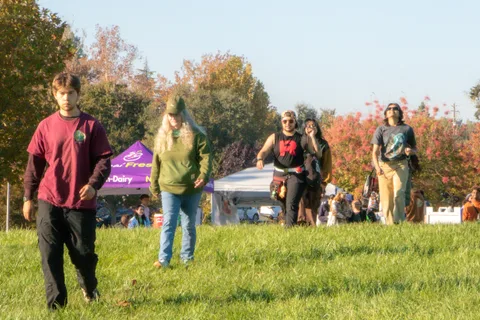 Two guests stand near a green demo tent with others scattered behind them.
