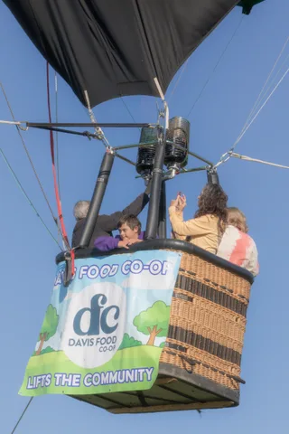 An older man and woman embrace warmly while riding together in the basket.
