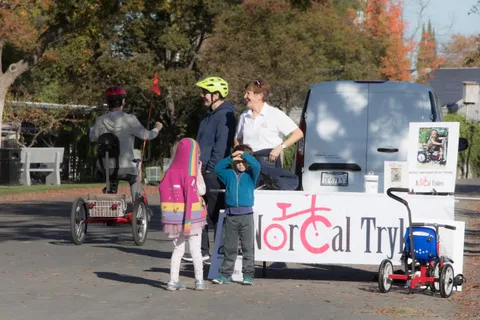 A family gathers near the NorCal Trykers trailer and display trike.