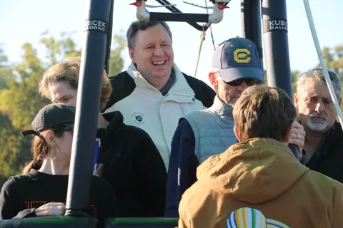 A man laughs mid-conversation with the group in the basket.