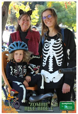 A mother and daughter in cat ears and a skeleton shirt smile together at the festival.