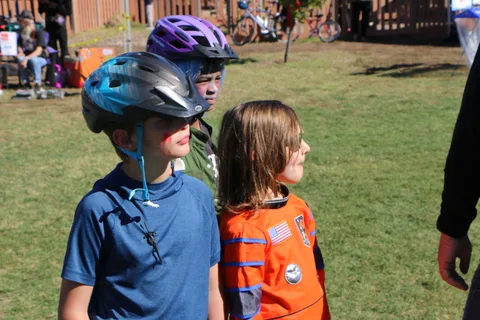Two boys in bike helmets share a playful moment at the festival.