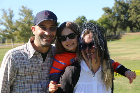 A man and two costumed companions pose for a second close-up photo.