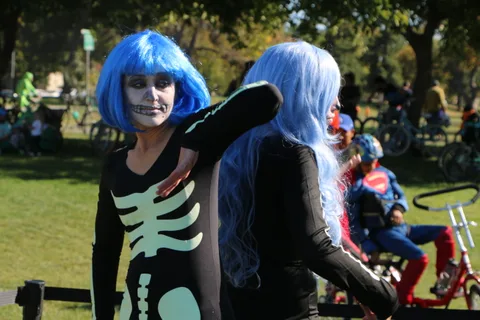 A couple in blue wigs and skeleton makeup pose together at the festival.