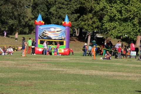 A colorful inflatable bounce castle stands on the festival lawn.