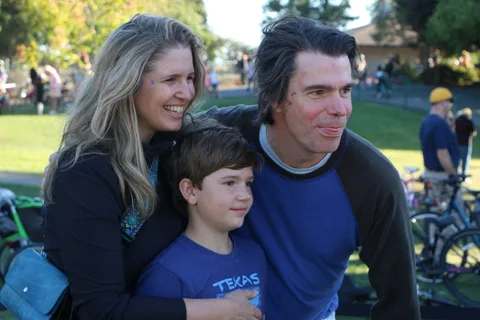 A family poses together at the festival in warm late afternoon light.