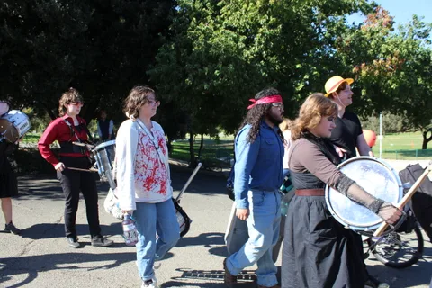 Costumed women walk together across the park.