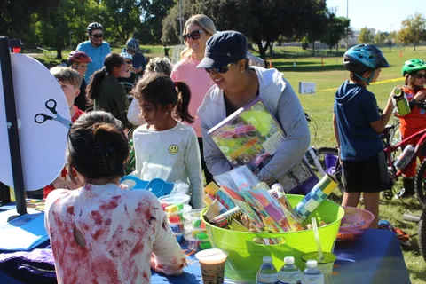 Kids gather at a craft table full of colorful supplies.