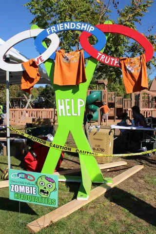 The Zombie Headquarters sign stands beside ring toss targets reading Friendship, Truth and Love.