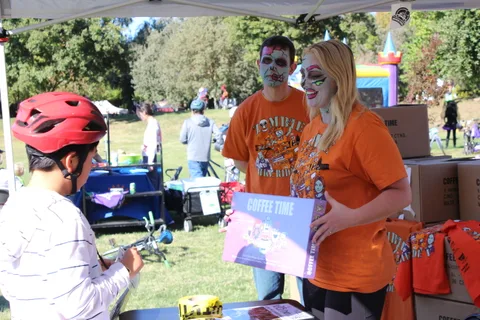 Two costumed volunteers pose at the Coffee Time booth.