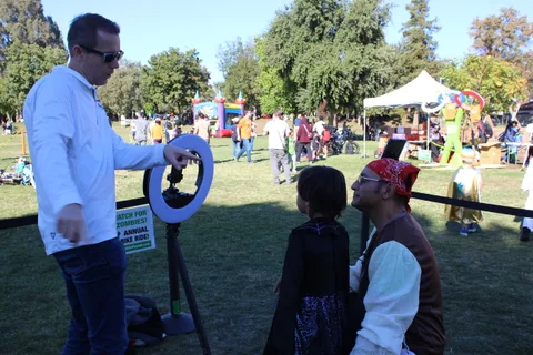 A photographer works with festival guests across the park.