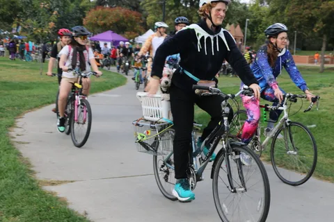 A costumed rider on an old-fashioned bicycle poses on the park path