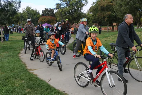 Young riders cycle through the park during the parade