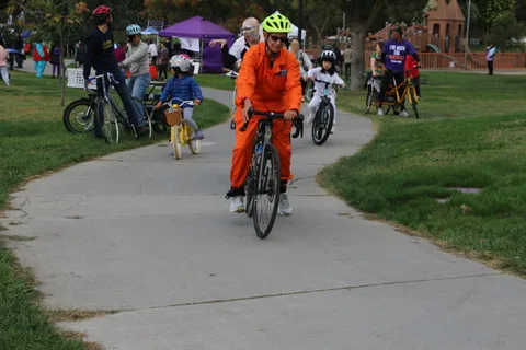 A costumed rider on a decorated bike at the park event