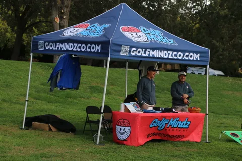 Guests visit a sponsor booth with branded tent and table