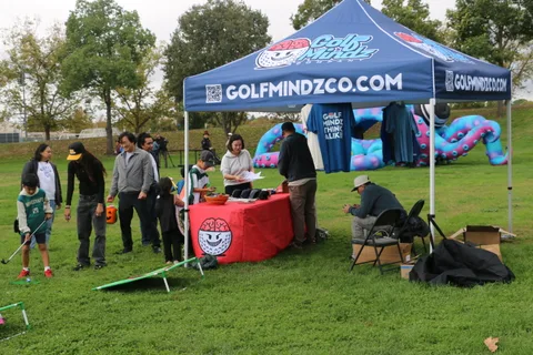 Vendors and visitors at event tents lined along the park
