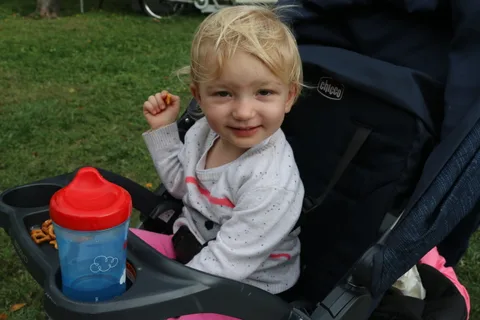 Happy toddler in a stroller smiling at the camera