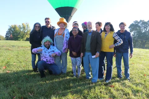 A group poses together on the grass at the outdoor event