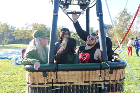Riders gather in the balloon basket in morning light.