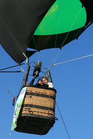 The balloon basket carries riders past the Davis Food Co-op banner.