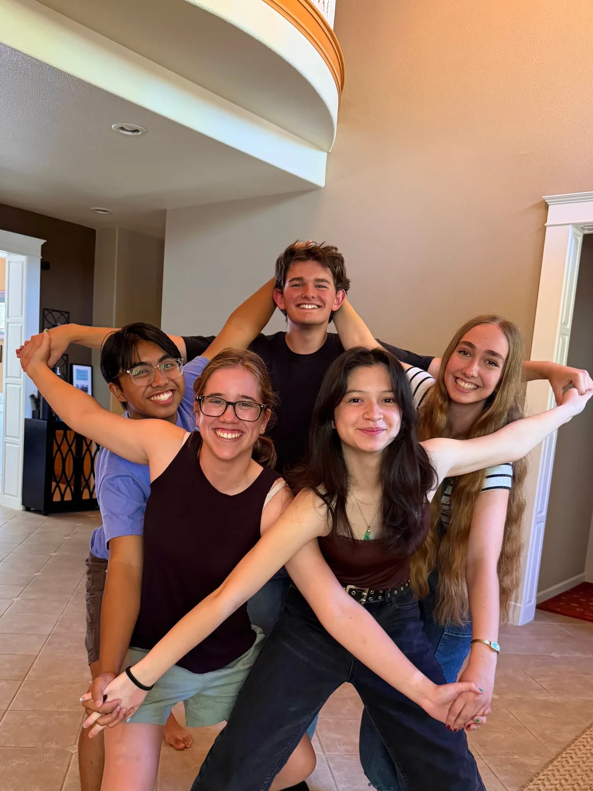 Betrayal: five of the band crowded together indoors, arms over each other’s shoulders, all grinning at the camera.