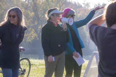 People with a megaphone talk together on a misty morning