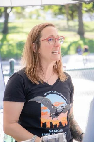 A visitor in a Mexican free tailed bat shirt listens at the bat booth.