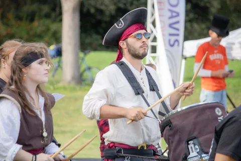 A pirate-costumed drummer performs with the festival drum corps at the Zombie Bike Parade