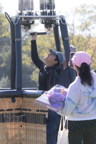 A crew member reaches up to the burner above the basket