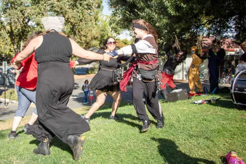 The band breaks into a circle dance on the grass while the crowd watches.