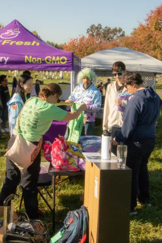 Volunteers hand out bags at a booth under the tents
