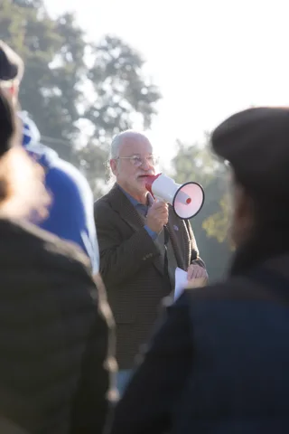 A person speaks into a megaphone to the crowd