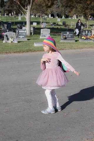 A child in costume runs along a path