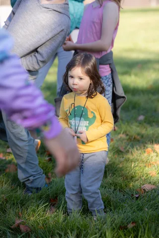 A young child stands on the grass at the festival