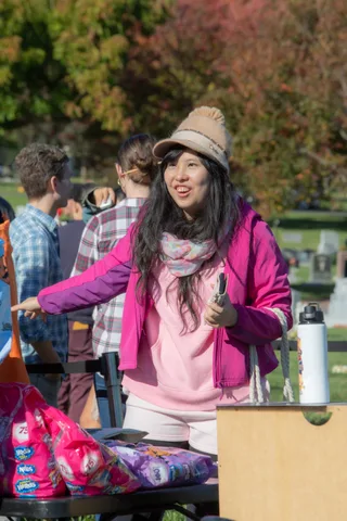 A volunteer at the merchandise table greets guests