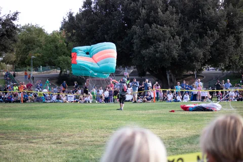 A bright canopy folds down onto the grass after the landing.