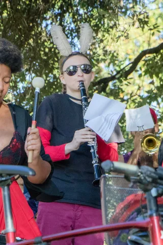 A clarinet player in bunny ears and sunglasses performs with the band.