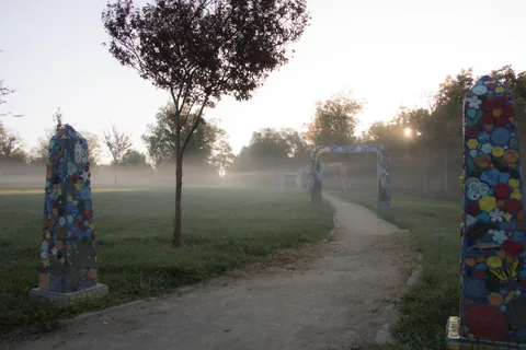 Painted posts line a misty path at sunrise