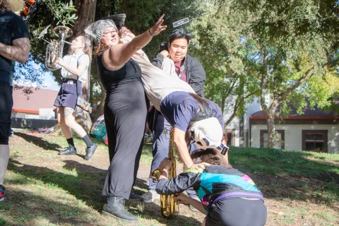 Band members strike a pose mid song, one arm thrown skyward while another bends low.