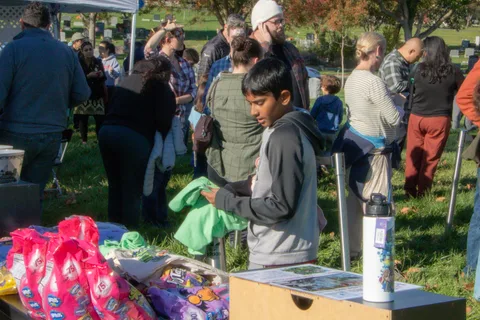 People crowd around the merchandise table at a booth