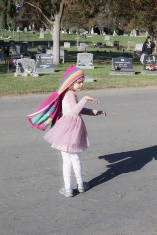 A child in costume plays on a path