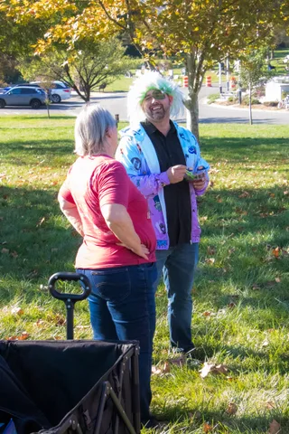 Two people stand talking together on the lawn