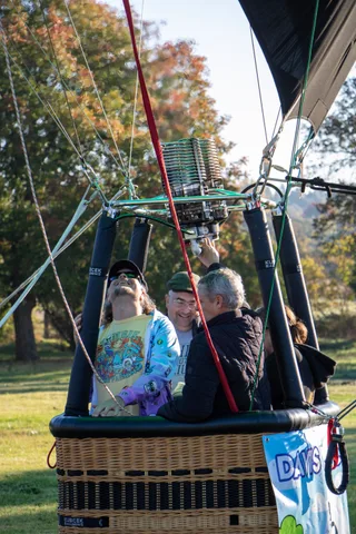 Passengers sit in a balloon basket ready to fly