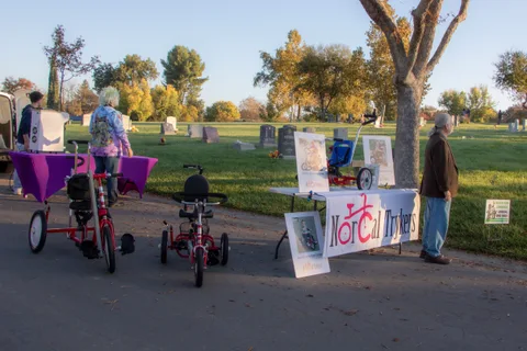 Trikes parked beside a bike club banner on the path