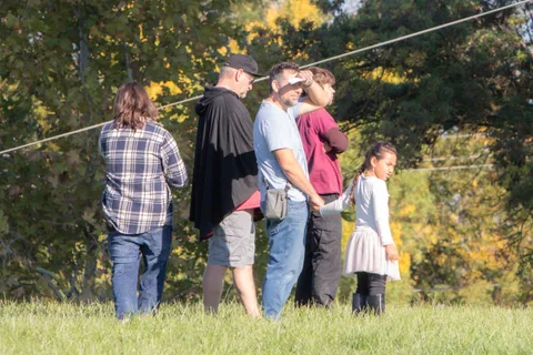 People gather on the lawn in the morning light