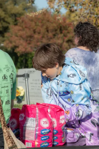 A child stands by a table of supplies at the booth