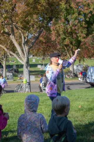 A person with a megaphone speaks to a seated group