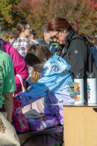 People gather around the merchandise table