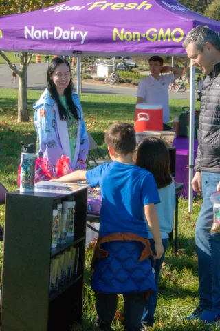 A volunteer helps a child at the merchandise table