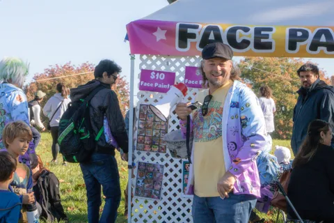 People gather at the face painting tent
